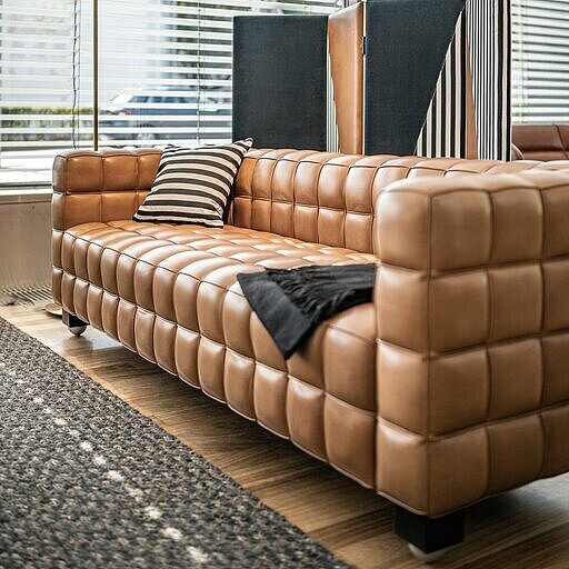 brown leather Kubus sofa in front of a paravent
