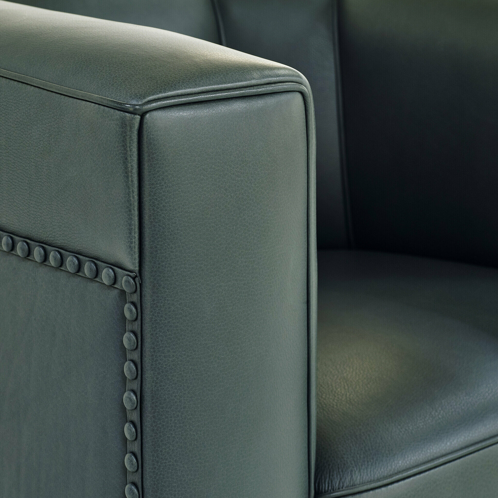armrest detail of a black Palais Stoclet leather armchair