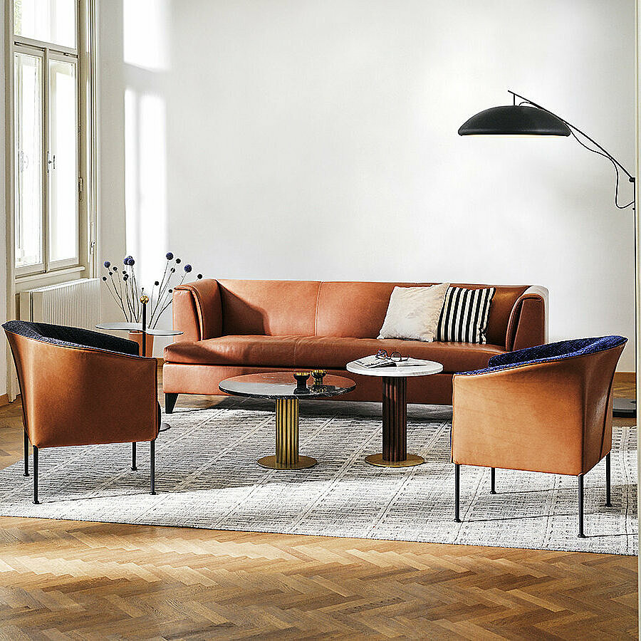 brown Havana leather sofa behind two Lilian fauteuils with leather exteriors and two Miles side tables
