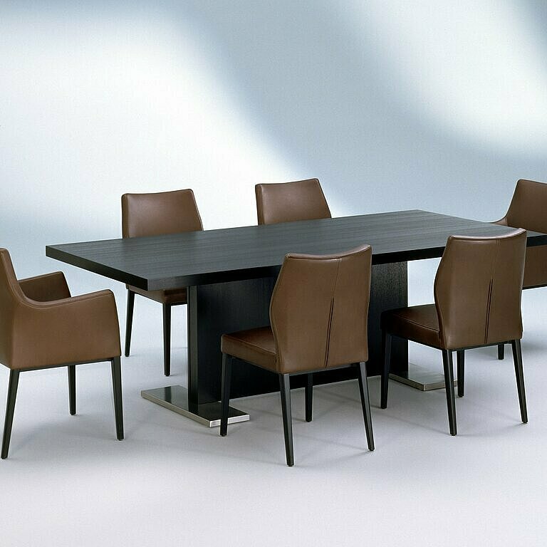 mit braunem Leder bezogene Toga Stühle um einen dunkelbrauen Tisch gruppiert