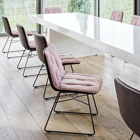 Shilo Stühle mit rosa Sitzmatte vor weißem Konferenztisch