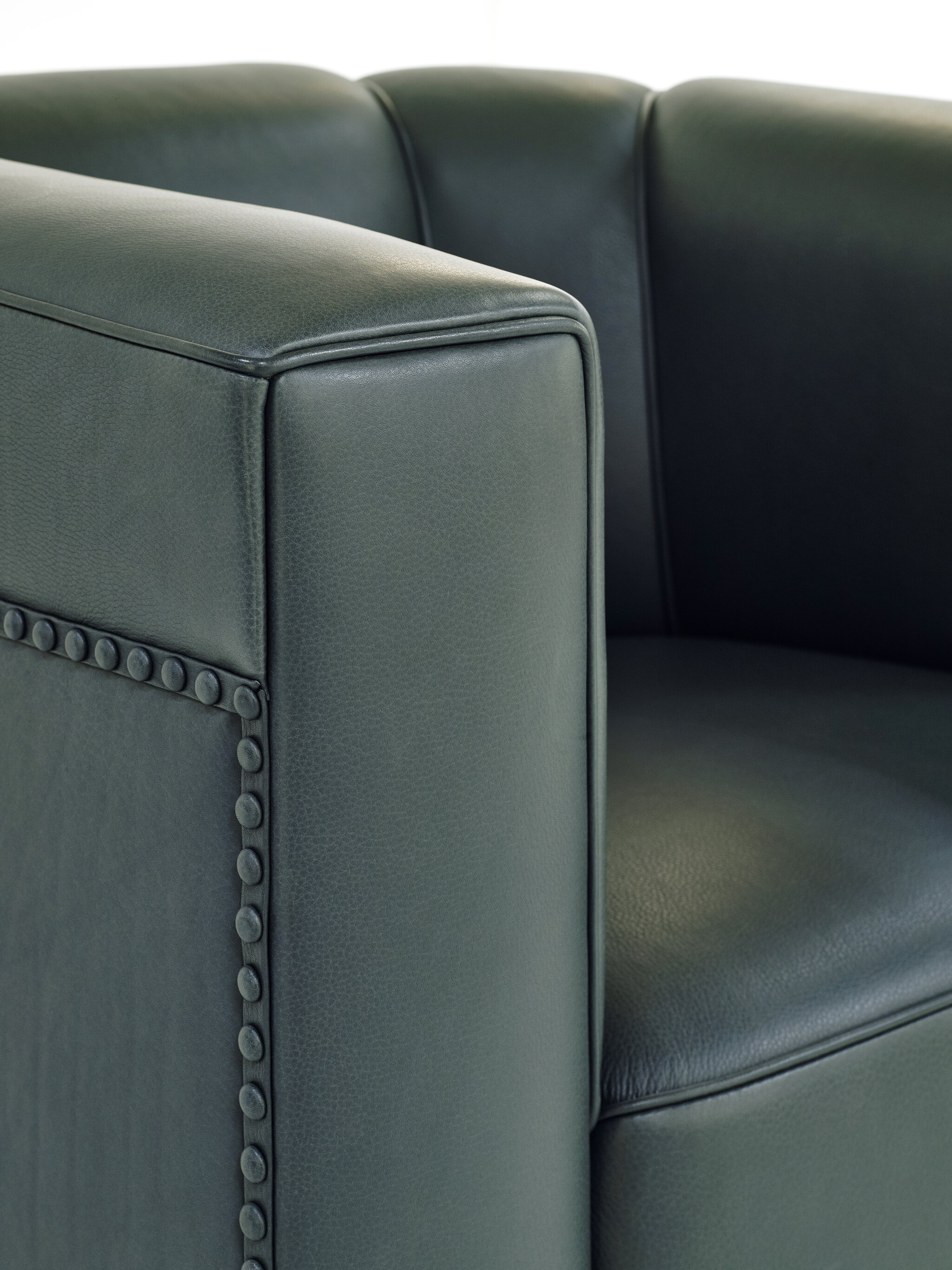 armrest detail of a black Palais Stoclet leather armchair