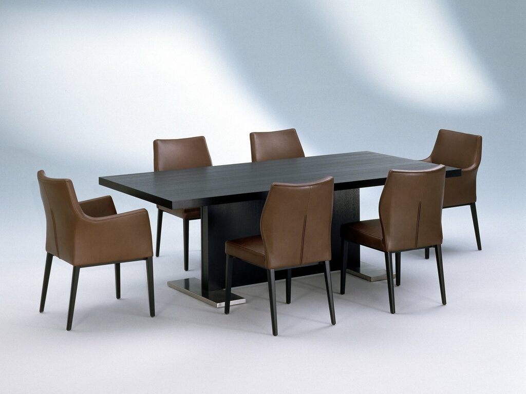 mit braunem Leder bezogene Toga Stühle um einen dunkelbrauen Tisch gruppiert