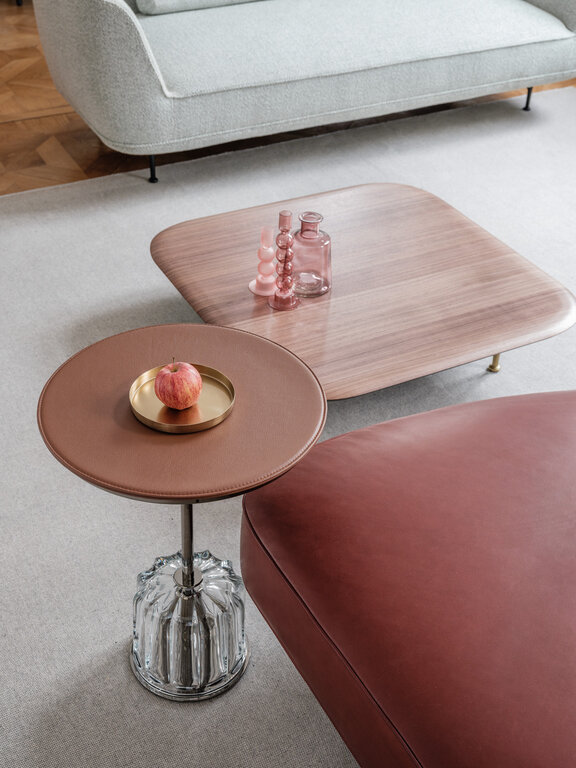 Acacia side table with brown leather covered table top and transparent glass base in front of brown Andes leather sofa